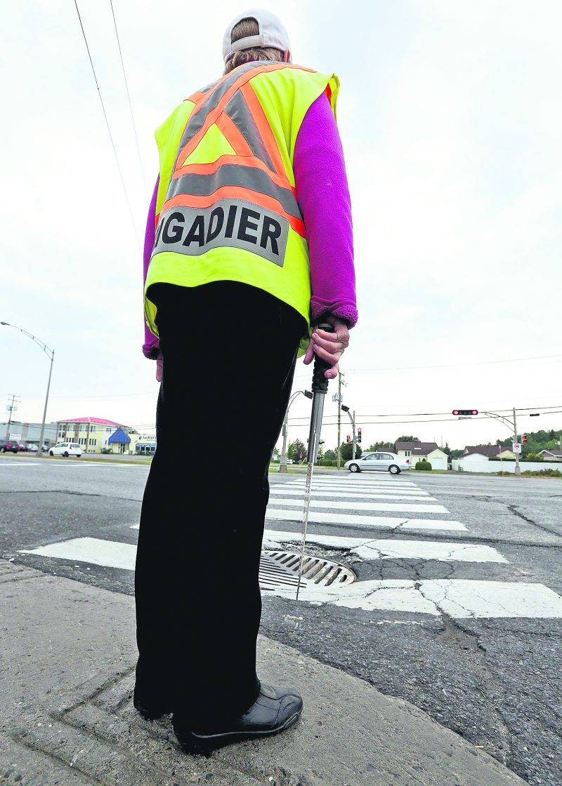 Les nouvelles directives de la Ville de Saint-Hyacinthe concernant la tenue vestimentaire de ses employés indisposent les brigadiers scolaires. Sur la photo, cette brigadière a décidé de se conformer à la politique. Photo Robert Gosselin | Le Courrier ©