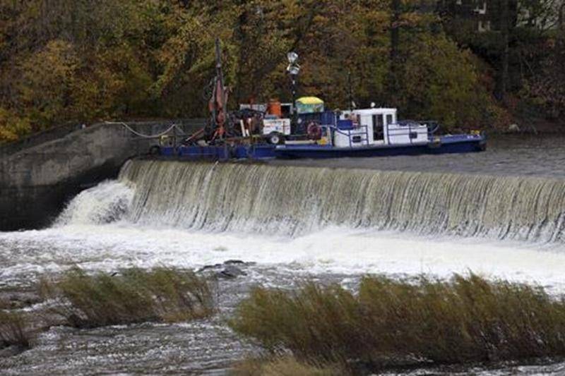 La phase I de travaux de consolidation est en cours au barrage Penman's, au centre-ville de Saint-Hyacinthe. Comme on peut le voir sur la photo, l'entrepreneur général utilise une barge pour procéder aux ancrages qui stabiliseront le déversoir de cet ouvrage en béton datant de 1900. Ces travaux sont réalisés par la compagnie Cimota, de Québec, qui a obtenu en septembre un contrat de 358 863 $ de la Ville de Saint-Hyacinthe. Des contrats totalisant 153 000 $ avaient précédemment été accordés à Te