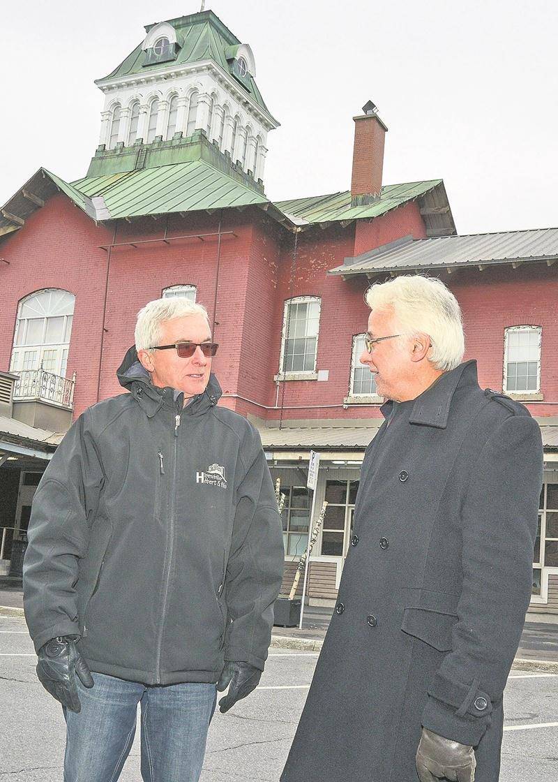 Bertrand Hébert et Raynald Therrien devant le Marché public de Saint-Hyacinthe. Ils ne comprennent pas que la Ville veuille remplacer la brique d’origine de son monument historique. Photo François Larivière | Le Courrier ©