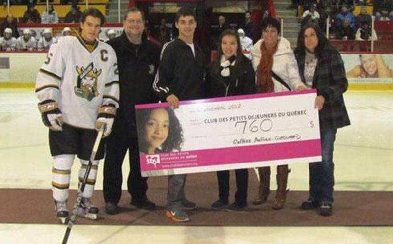 Avant la partie des Gaulois du Collège Antoine-Girouard au Stade L.-P.-Gaucher le 25 novembre, un chèque d'un montant de 760 $ a été remis au Club des Petits Déjeuners du Québec. Le CAG soulignait ainsi son engagement au Club des Petits Déjeuners depuis quatre ans. Deux activités de levée de fonds ont permis d'amasser ce montant. Sur la photo, Anthony Beauregard, capitaine des Gaulois, André Plante, directeur des services éducatifs, Alex Girouard et Emma P. Bélanger, étudiants engagés de 5<sup>e